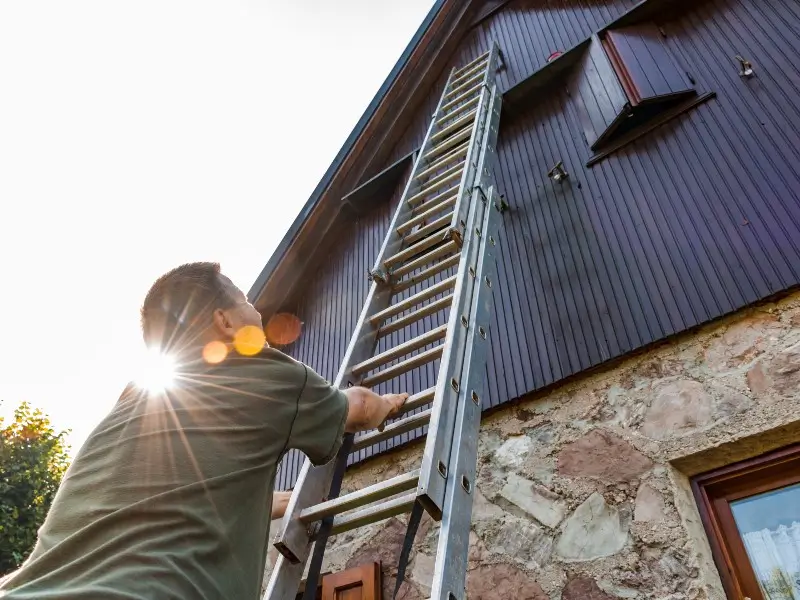 man climbing tall ladder