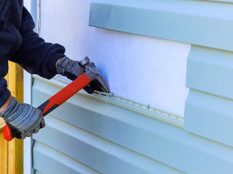 Man repairing siding on a home in North Carolina.