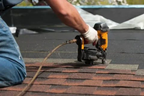 Man installing new shingles on a roof in NC