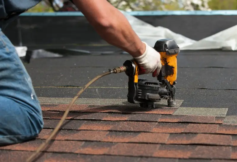 Man installing new shingles on a roof in NC